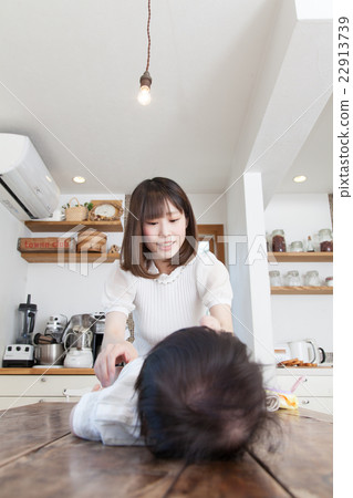 換尿布的年輕母親 換尿布的年輕母親 22913739