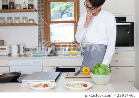 A man in a kitchen tilting his neck 22914463