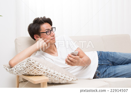 我有一個年輕人的智能手機,躺在沙發上 我有一個年輕人的智能手機,躺在沙發上 22914507