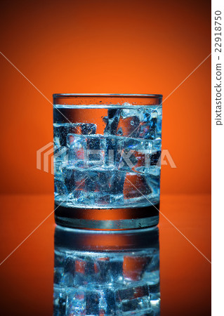 Close up of cold water glass with ice cubes. Close up of cold water glass with ice cubes. 22918750