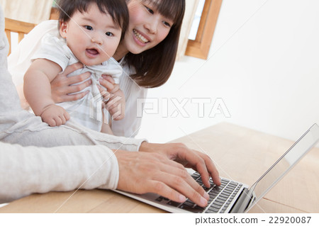 A young family watching a computer at home 22920087