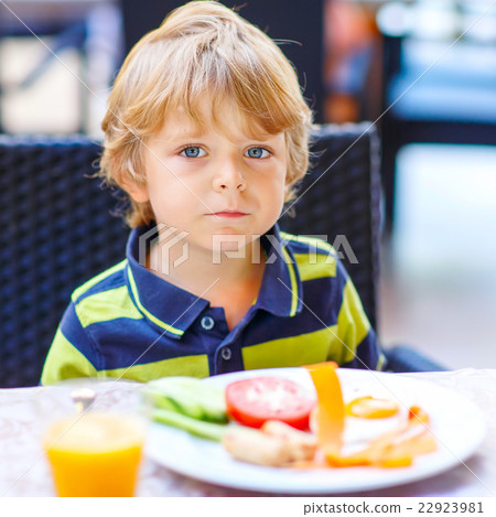 Little kid boy having healthy breakfast in Little kid boy having healthy breakfast in 22923981