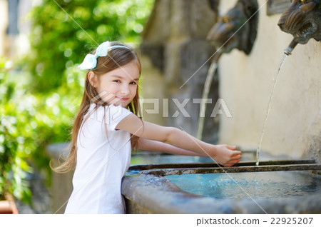Little girl playing with a drinking water fountain Little girl playing with a drinking water fountain 22925207