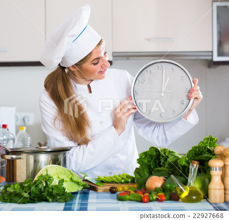Girl in chef uniform with clock and veggies at kitchen Girl in chef uniform with clock and veggies at kitchen 22927668