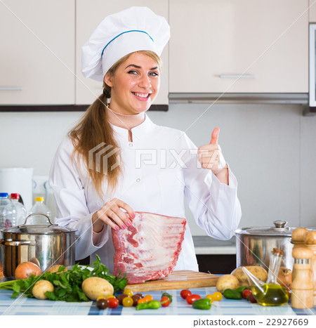 Professional female cook with ribcage in kitchen 22927669