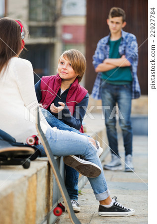 Upset boy and couple of teens apart on the street 22927784