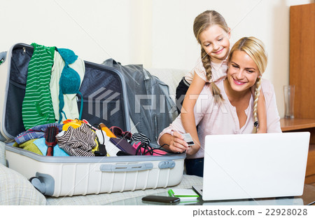Mother with daughter near suitcase with credit card Mother with daughter near suitcase with credit card 22928028