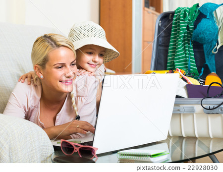 Woman with daughter planning vacation. Woman with daughter planning vacation. 22928030