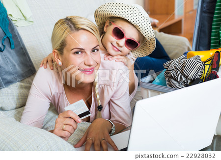 Mother with daughter near suitcase with credit card Mother with daughter near suitcase with credit card 22928032
