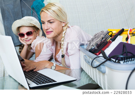 Mother with daughter near suitcase with credit card 22928033