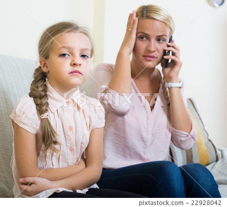 Worried mother calling doctor for daughter with abdominal pains 22928042