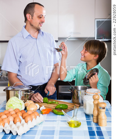 Man and teenager cooking together 22928059
