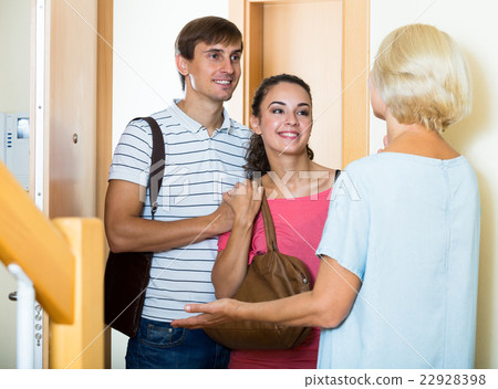 Cheerful senior woman greeting adult children coming with visit Cheerful senior woman greeting adult children coming with visit 22928398