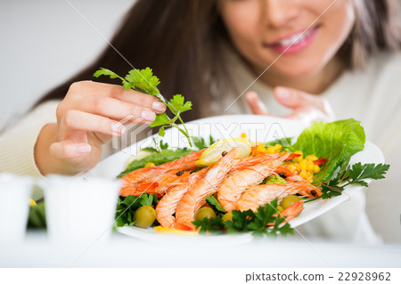 Woman decorating fried prawns 22928962