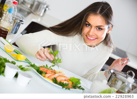 Girl decorating fried fish on plate 22928963