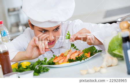 Young smiling chef with fried shrimps indoors Young smiling chef with fried shrimps indoors 22928965