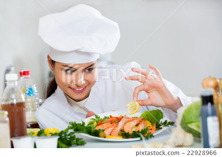 Young  smiling cook arranging shrimps 22928966