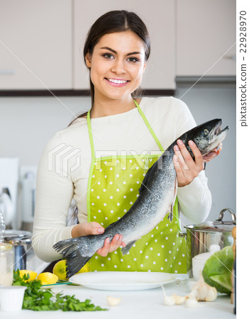 girl holding rainbow trout in domestic kitchen 22928970