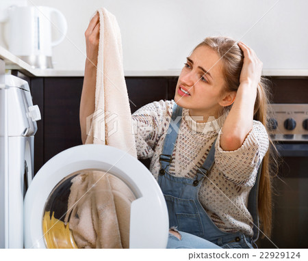 Upset sad girl looking at stains on towels Upset sad girl looking at stains on towels 22929124