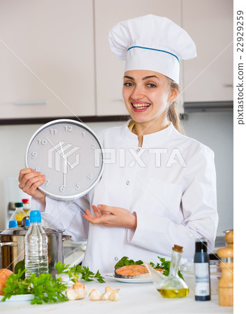 Female chef counting time down for cooling fish 22929259