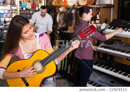 People looking at musical instruments 22929313