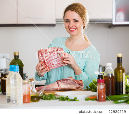Young woman cooking lamb for dinner at home 22929339