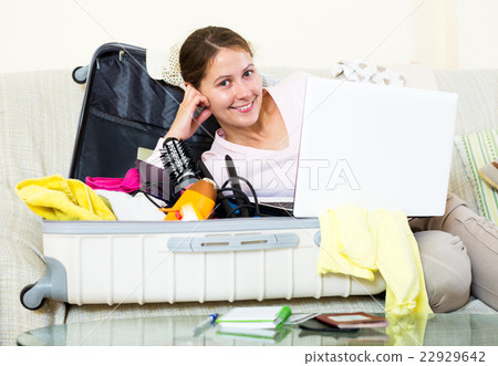 Woman with packed baggage and notes Woman with packed baggage and notes 22929642