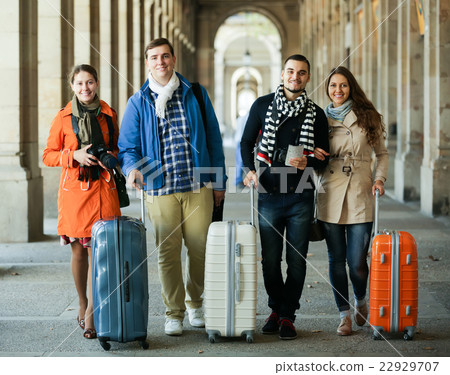 travelers with baggage sightseeing and smiling in autumn 22929707