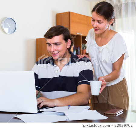 Wife taking care of working husband . Wife taking care of working husband . 22929762