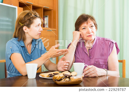 Female pensioner having conversation with her daughter Female pensioner having conversation with her daughter 22929787