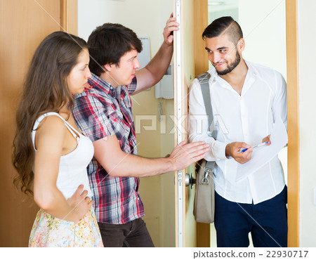 Serious couple and salesman talking 22930717