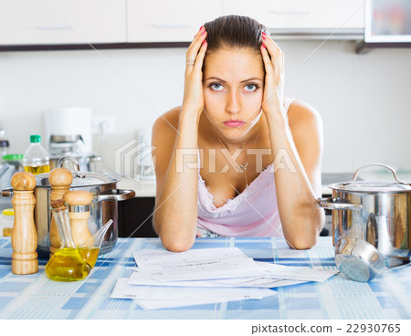 Tired housewife reading bills Tired housewife reading bills 22930765