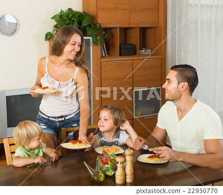Family of four eating spaghetti Family of four eating spaghetti 22930770