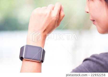 young woman looking at her smart watch young woman looking at her smart watch 22932258