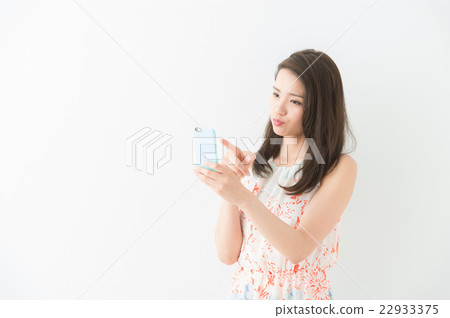A woman who operates a smartphone (white background) A woman who operates a smartphone (white background) 22933375
