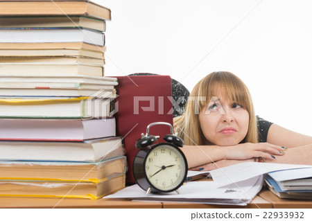 Student with despair looking at a big stack of books 22933932