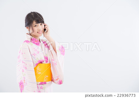 A woman in a yukata that uses a smartphone A woman in a yukata that uses a smartphone 22936773