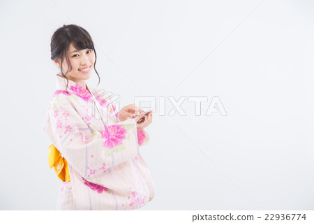 A woman in a yukata that uses a smartphone A woman in a yukata that uses a smartphone 22936774