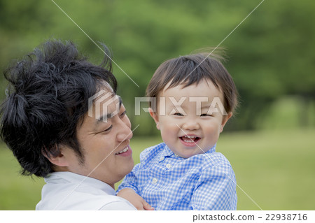 A boy laughing in a father in a park 22938716