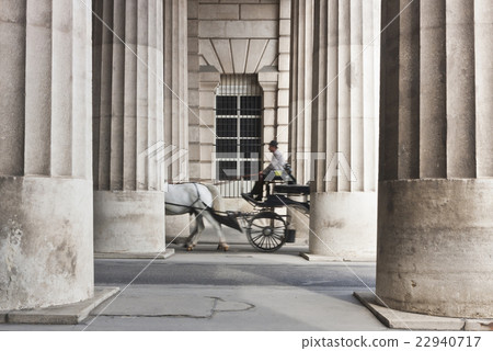 Horse-drawn carriage passing through the colonnade 22940717