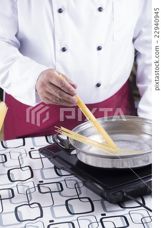 Chef putting spaghetti to boiled in the pan Chef putting spaghetti to boiled in the pan 22940945