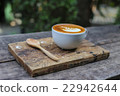 A cup of coffee with wooden spoon in outdoor cafe 22942644