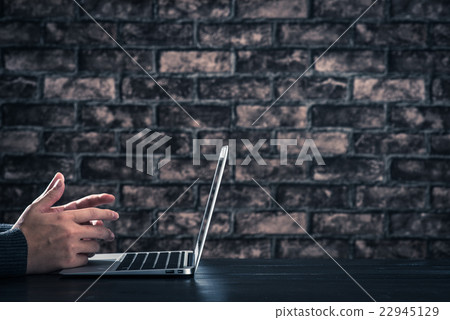 Male hand operating laptop dark room brick wall Male hand operating laptop dark room brick wall 22945129