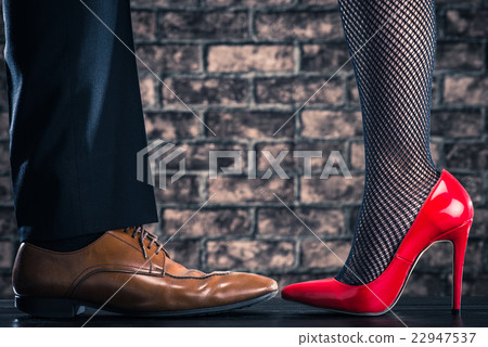 女士和男士的皮鞋穿著紅色高跟鞋 22947537