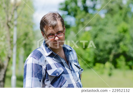 Man is looking over his glasses with skepticism Man is looking over his glasses with skepticism 22952132