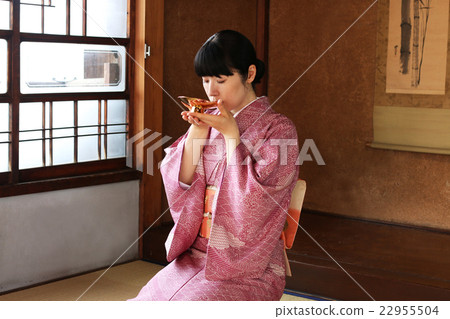 A woman in kimono drinking slaughter at a cup 22955504