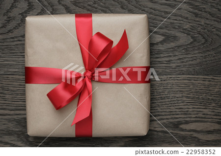 brown gift box with red bow on wood table brown gift box with red bow on wood table 22958352