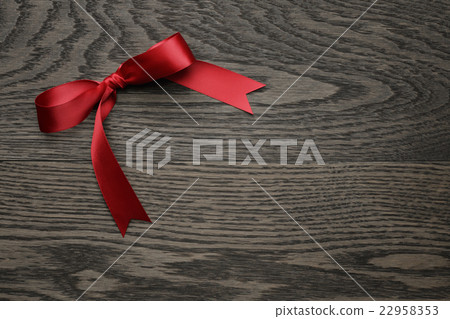 red ribbon bow on old oak table red ribbon bow on old oak table 22958353