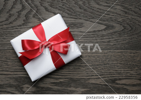 gift box with red bow on wood table gift box with red bow on wood table 22958356