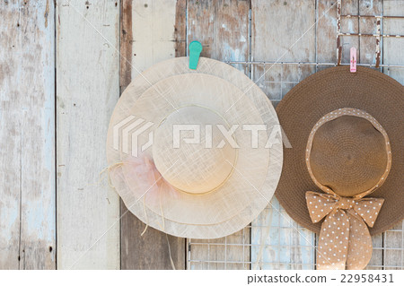 Straw hats for sale, hanging on a wall.. 22958431